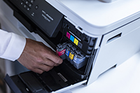 colour cartridges in SOHO printer magenta ink being installed by man