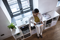 woman by printer with outputs in a SOHO environment 