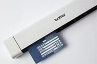 Brother DSmobile DS640 portable document scanner with blue ID card inserted into the scanner