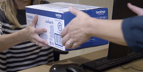Ženska daje škatlo tonerja za tiskalnik drugi ženski