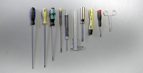 Izvijači, škarje in drugo orodje, pritrjeni na steno