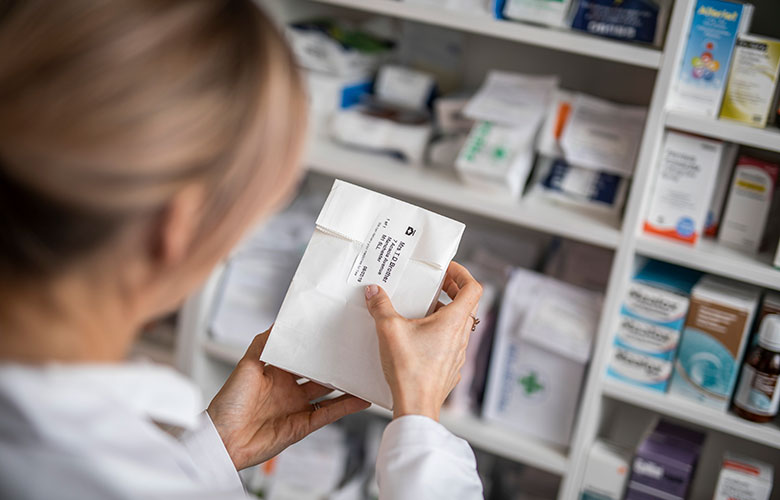 Medicine bag being labelled in pharmacy