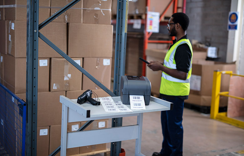 TD label printer printing labels on warehouse trolley with scanner