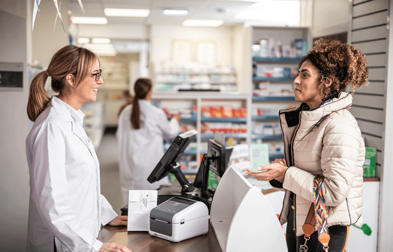 Pharmacist talking to female customer in pharmacy