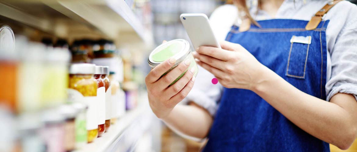 Femme scannant une boîte de conserve avec son smartphone