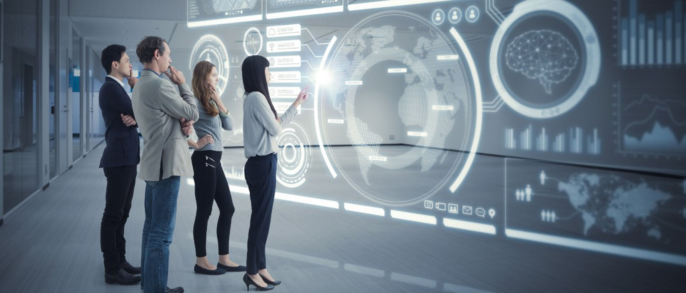 Plusieurs personnes regardent un tableau transparent affichant des données en réalité augmentée.