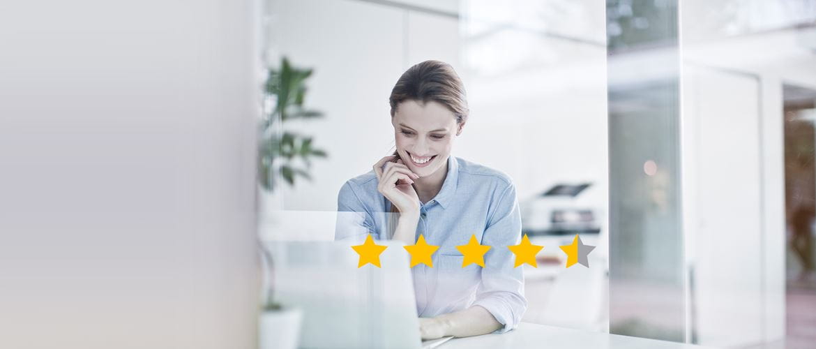 Women on a laptop leaving a review with star ratings in front of her