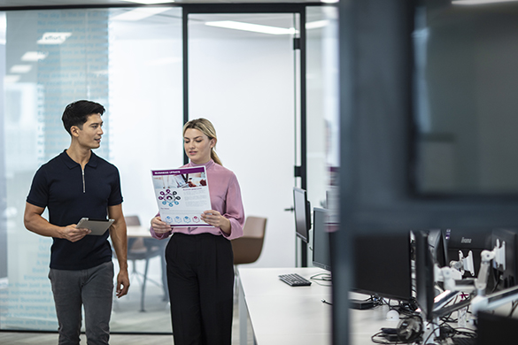 Un homme et une femme regardant un document debout dans un bureau
