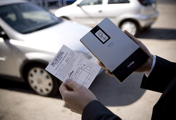 Imprimante MW tenue à la main par un homme avec un formulaire de location de voiture format A6 imprimé