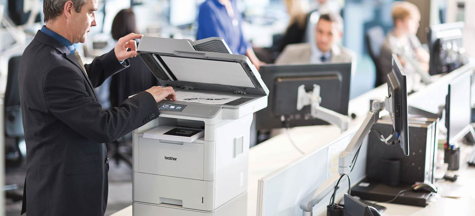 un homme photocopie un document avec l'imprimante Brother MFC-L6900DW