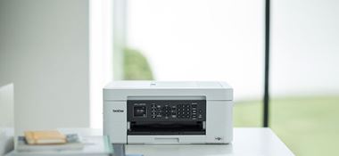 L'imprimante jet d'encre Brother MFC-J497DW posée sur le bureau d'un particulier à son domicile