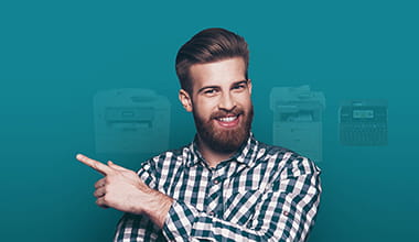 Homme souriant pointant du doigt des imprimantes Brother dans le fond