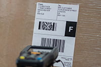 Étiquette avec code à barres thermique de haute qualité collé sur un carton en cours de lecture