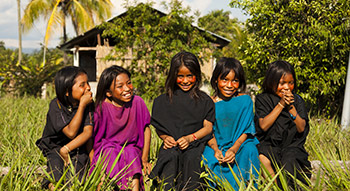 Plusieurs enfants prennent la pose alors qu'ils jouent dans les hautes herbes