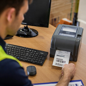 Un professionnel imprime une étiquette à l'aide d'une imprimante bureautique