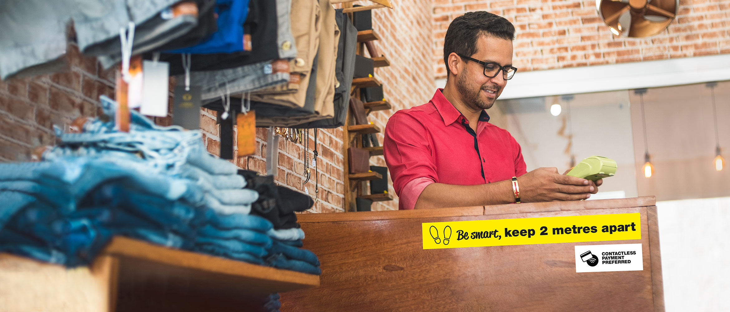 man taking a payment behind a till in a retail environment