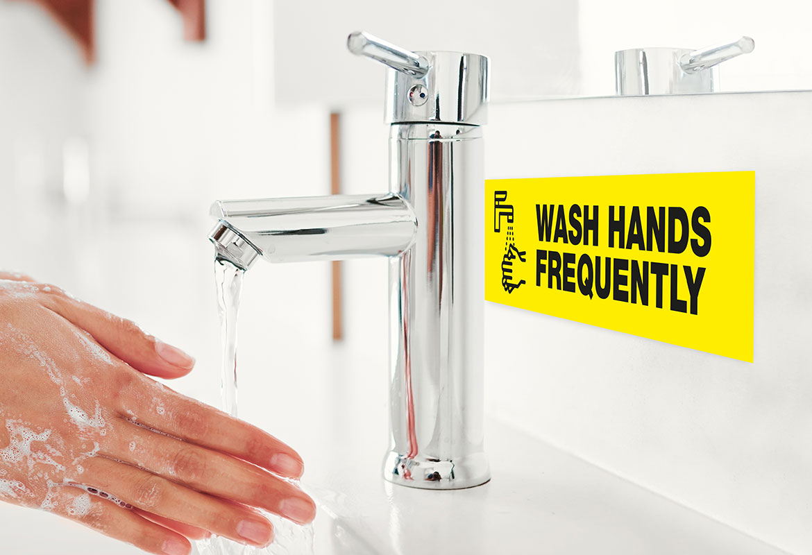 hands being washed with label visible on the splash back