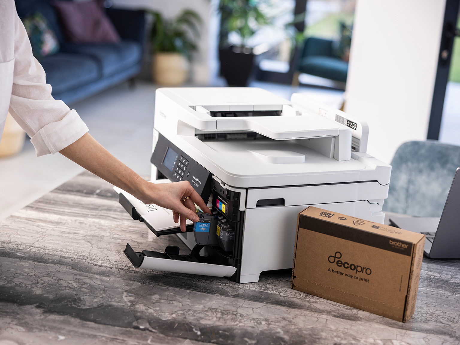 A woman putting Brother cartridges from an EcoPro subscription into her Brother printer 