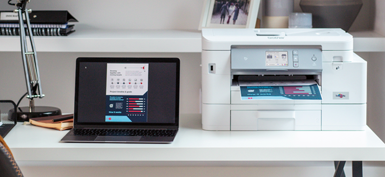 Brother MFC-J4540DW inkjet printer sat on a desk next to a laptop 