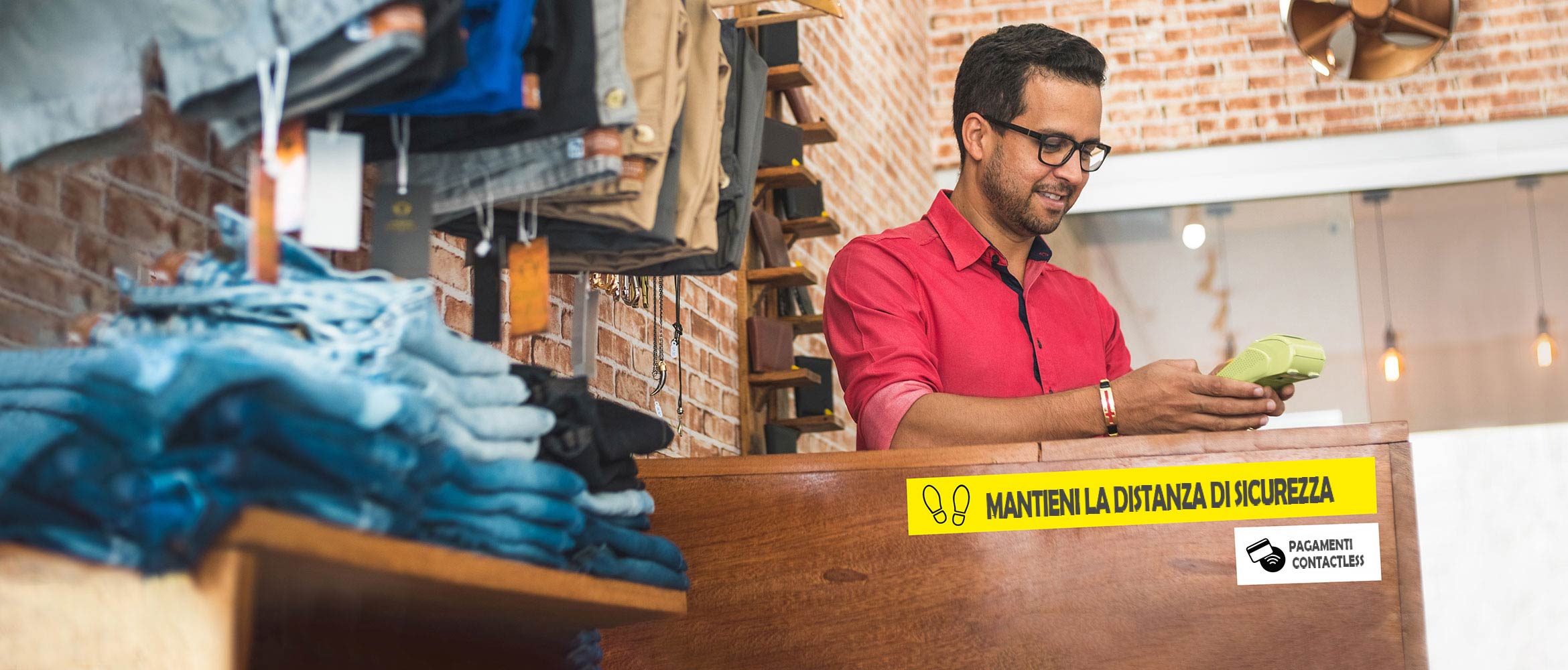 Commesso in un negozio di abbigliamento accetta pagamenti contactess