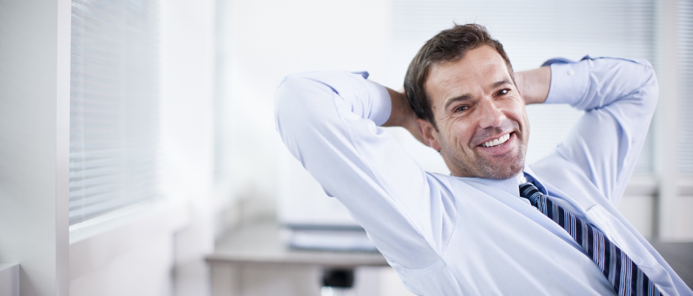 Impiegato sorridente in ufficio con camicia e cravatta