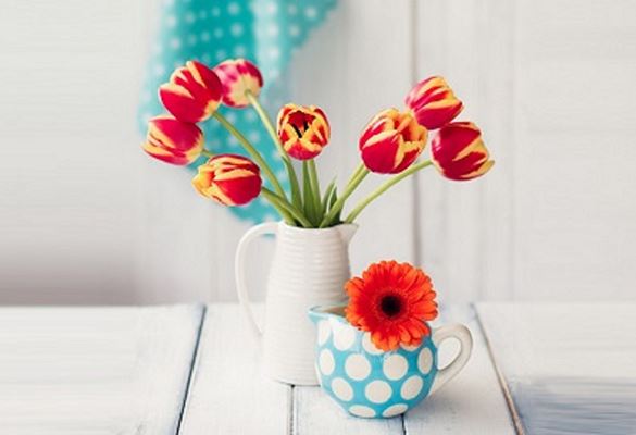 Vaso e tazza con fiori su scrivania