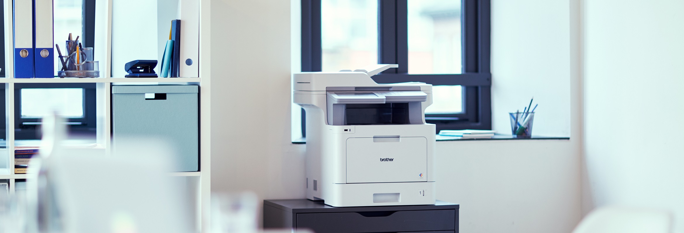 Stampante multifunzione laser a colori Brother MFCL9570CDW su un comodino in uffico