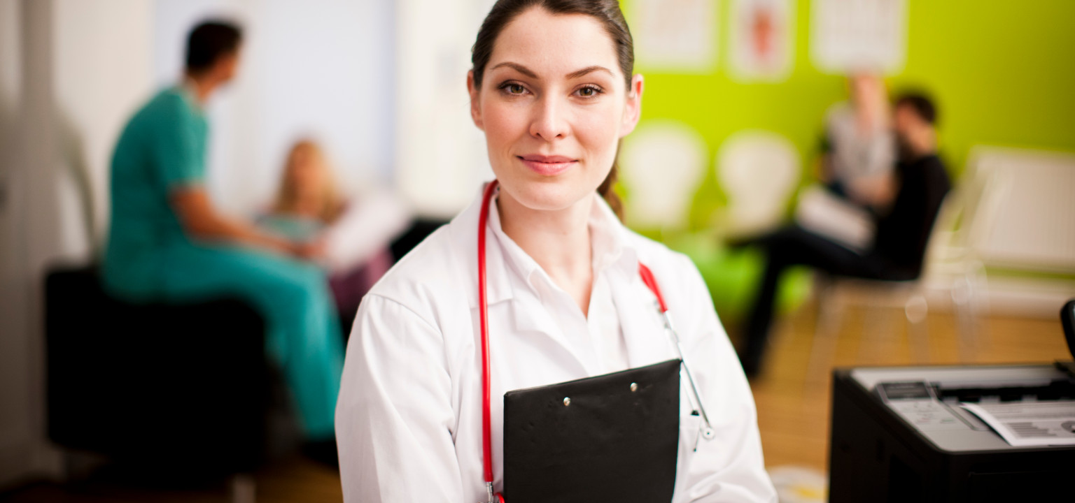 medico donna sorridente. sullo sfondo colleghi che parlano e stampante Brother sullo sfondo