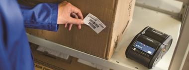 Lavoratore etichetta scatolone in magazzino con stampante Brother RJ3150