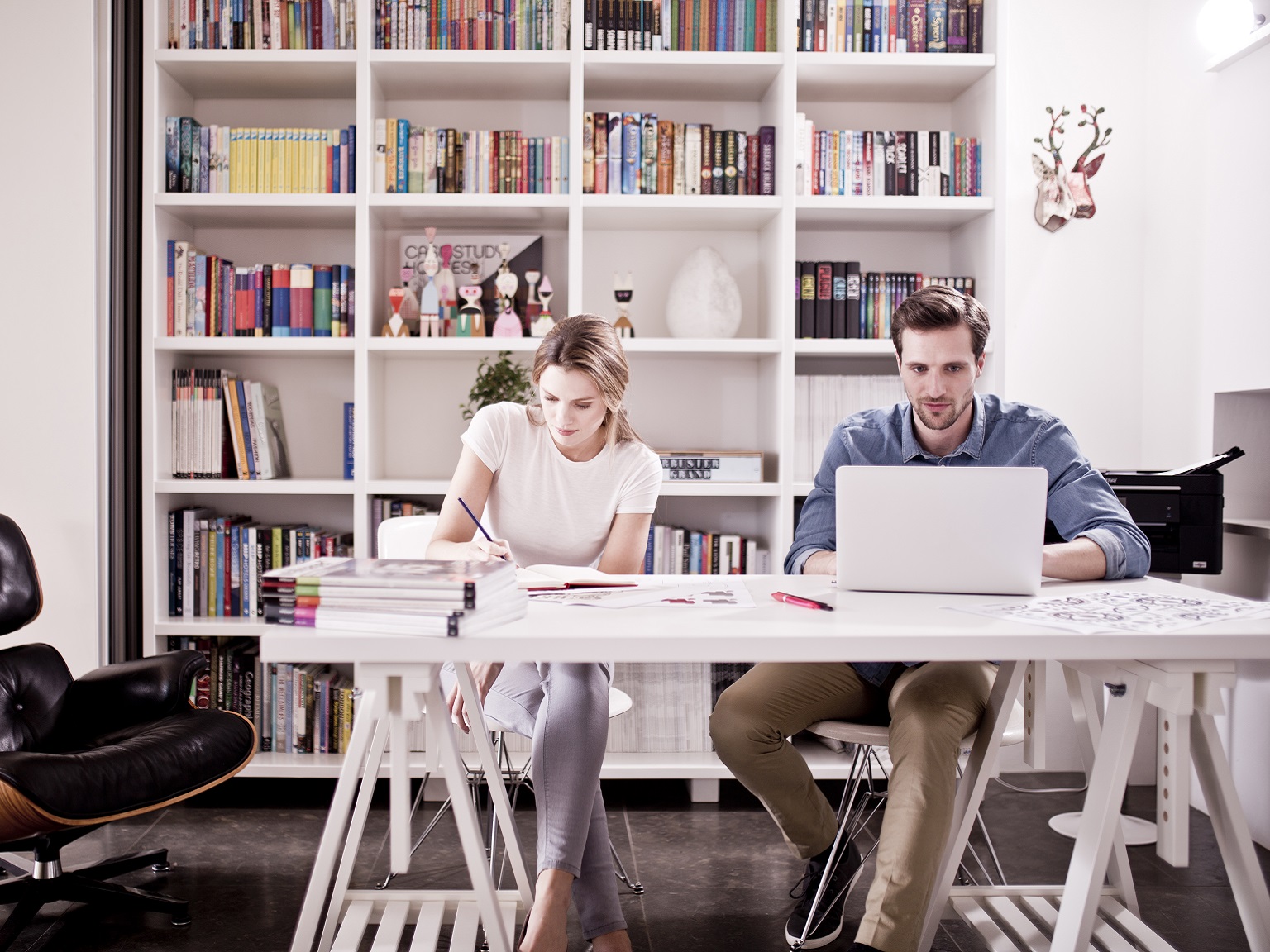 Colleghi al lavoro in ufficio SOHO con stampante multifunzione Brother