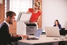 Impiegata in ufficio al lavoro con lo scanner della stampante multifunzione LED a colori Brother DCP9020CDW