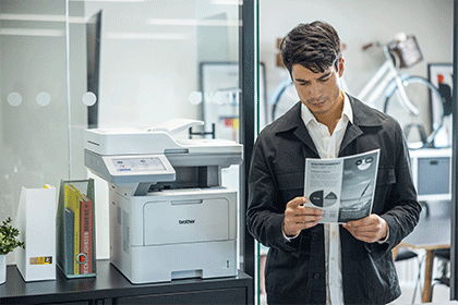 Uomo con documento A4 accanto alla stampante MFC-L6910DN