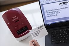 QL-600B su una scrivania con un'etichetta appena stampata