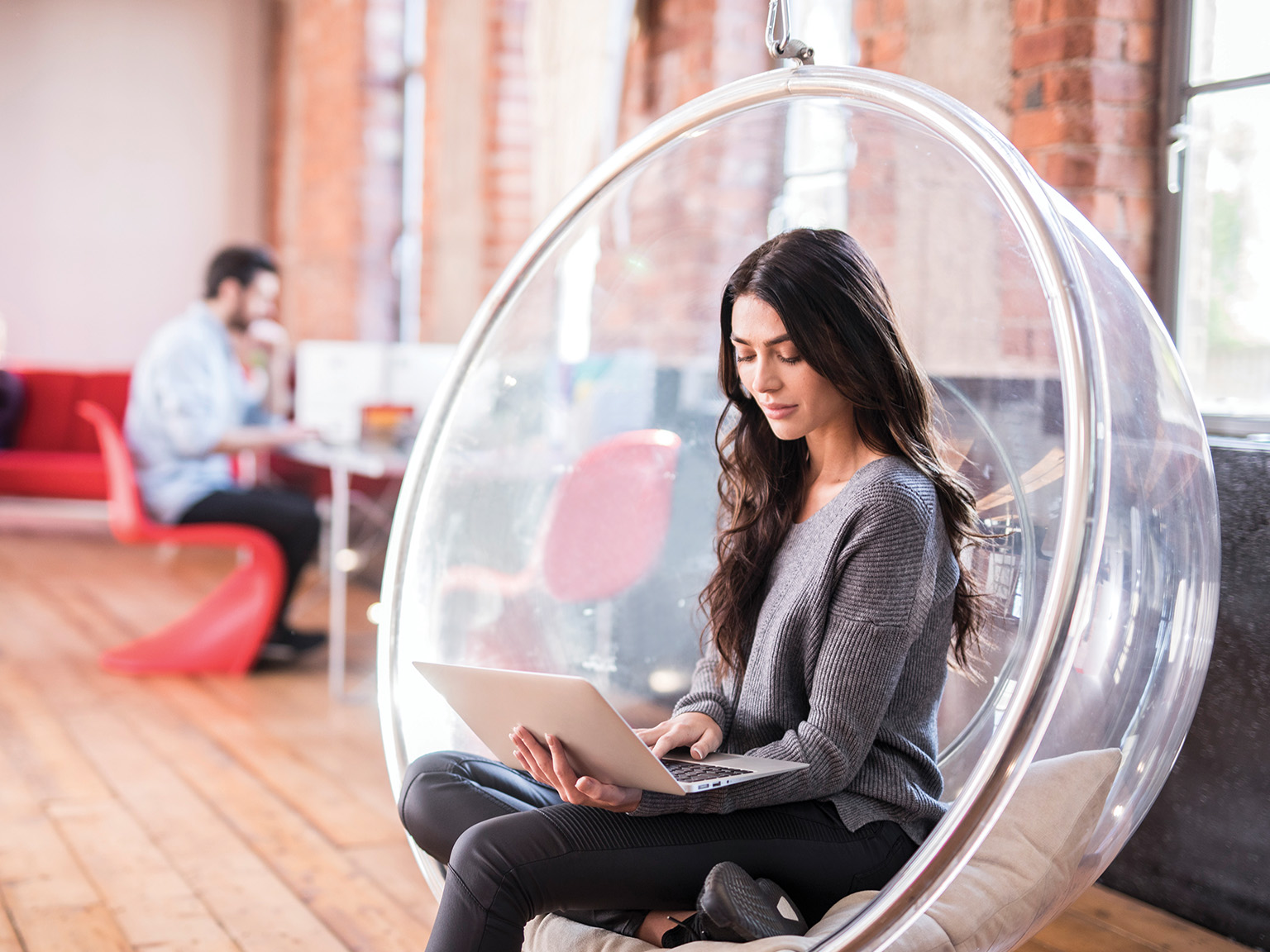 Woman sat down with laptop in an office enviroment
