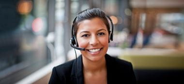 Woman with hair tied back sat with a headset on head