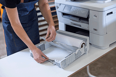 Person opening paper tray on large format printer showing A4 and roll paper