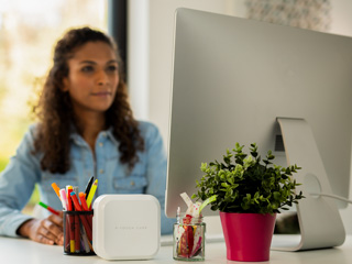 Woman using a Mac to print to her P-touch CUBE Plus label printer