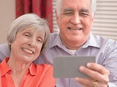 Grandparents watching a video of their family after scanning a QR code printed on a Brother P-touch label