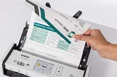 Person holding 2 sided A4 document in ADF of Brother ADS-1800W scanner