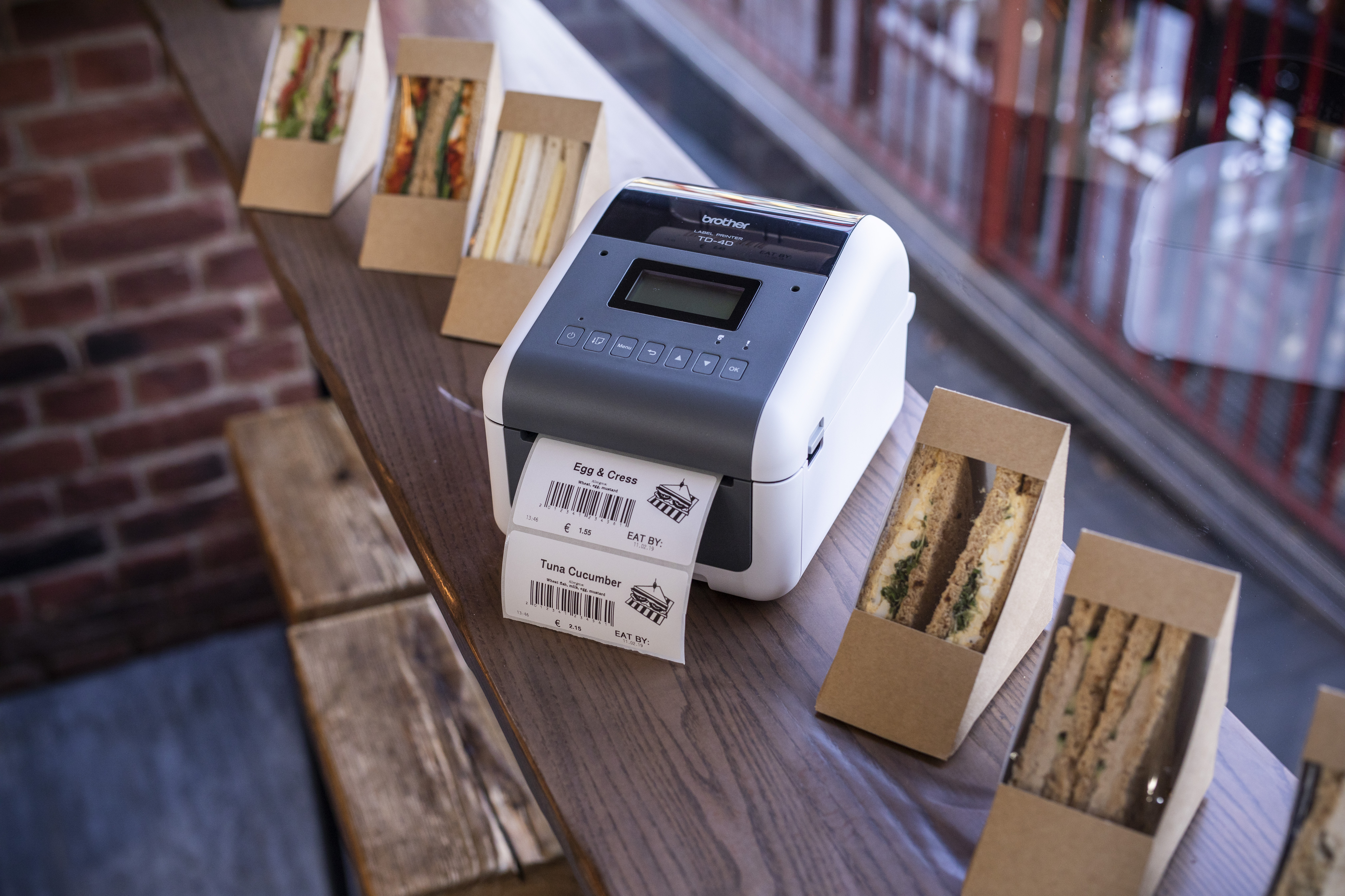 TD-4D labelling machine printing a label to stick on sandwich boxes in a deli retail area