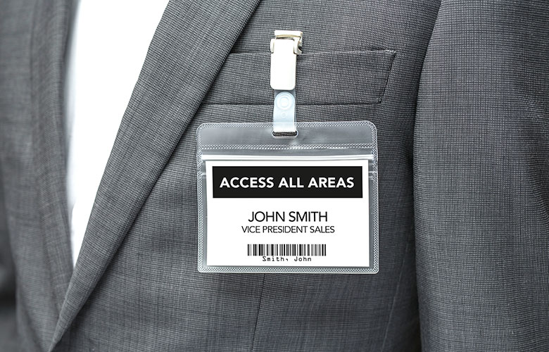 Visitor badge attached to person wearing grey suit jacket