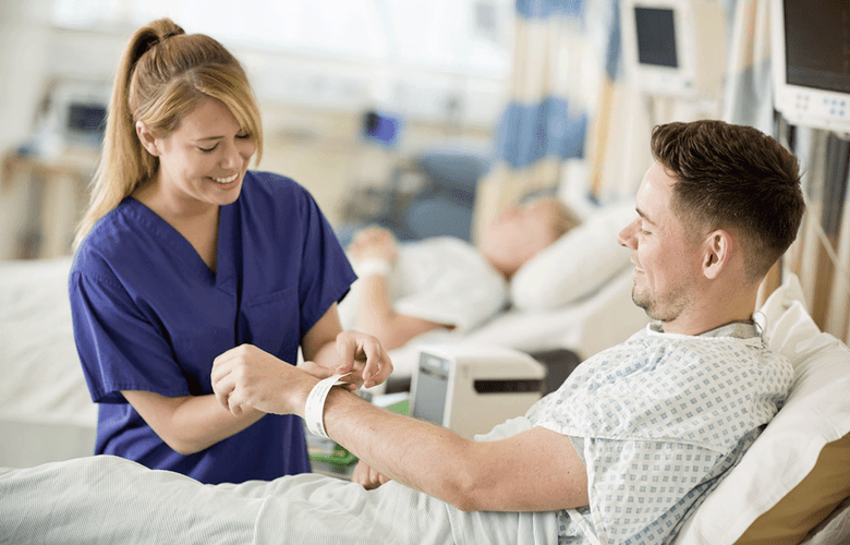 Nurse putting wristband on male patient with TD printer