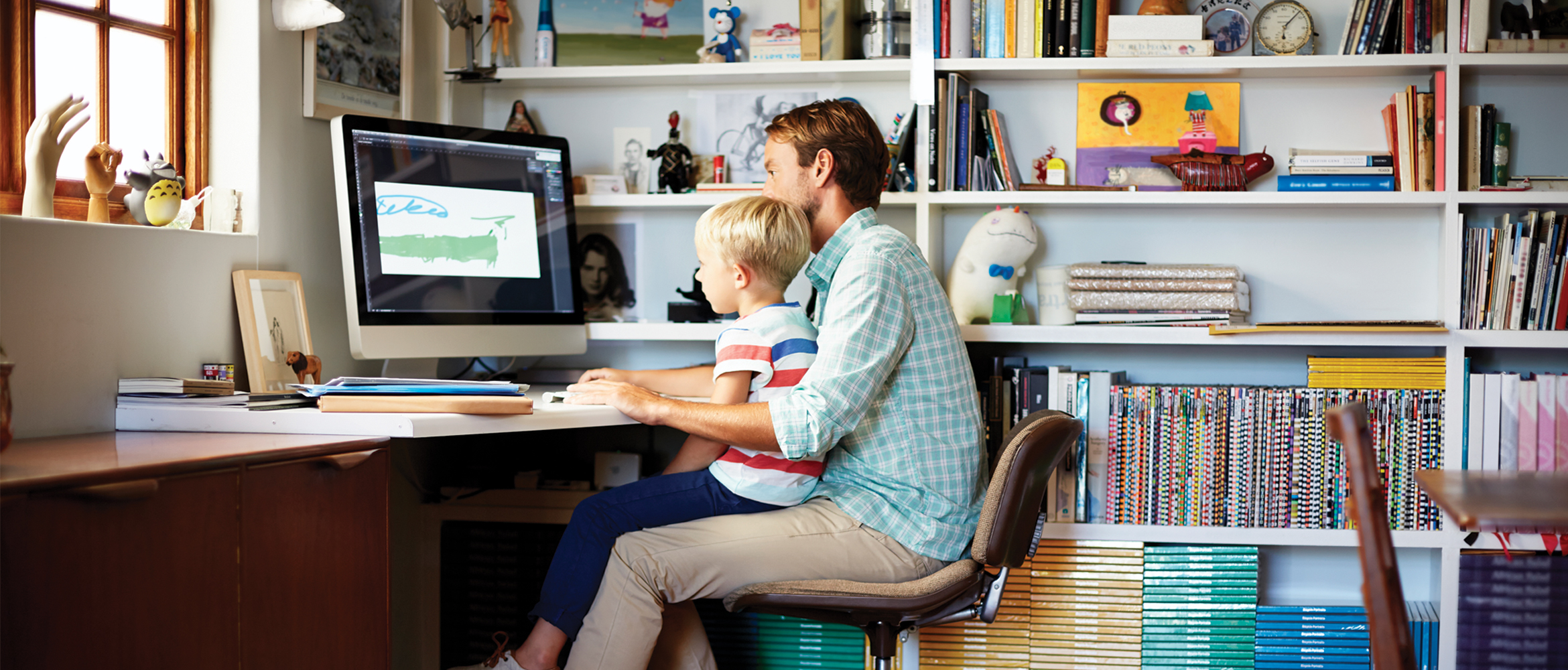 father and son sat desk working