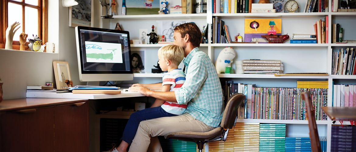 Isä ja lapsi istuvat työpöydän ääressä