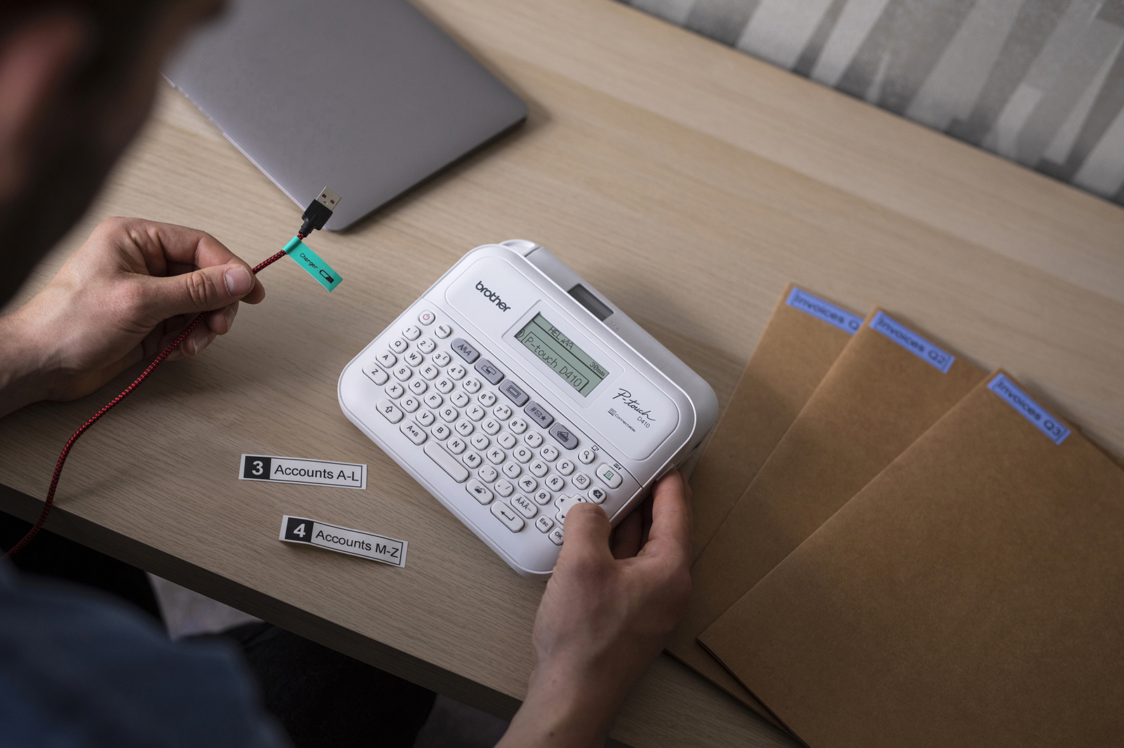 Brother labelling machine printing labels from a smartphone. Various labels on table.