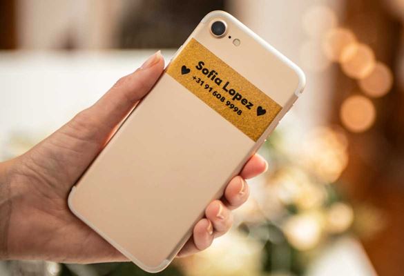 Black on premium gold glitter label on smartphone with owner's name and contact number