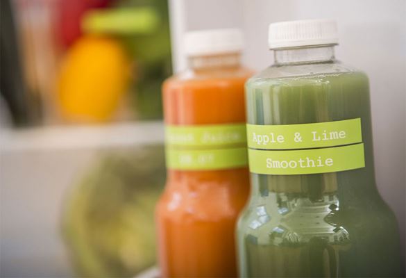 Fruit smoothie drinks in a fridge labelled with white on lime green matt laminated labels