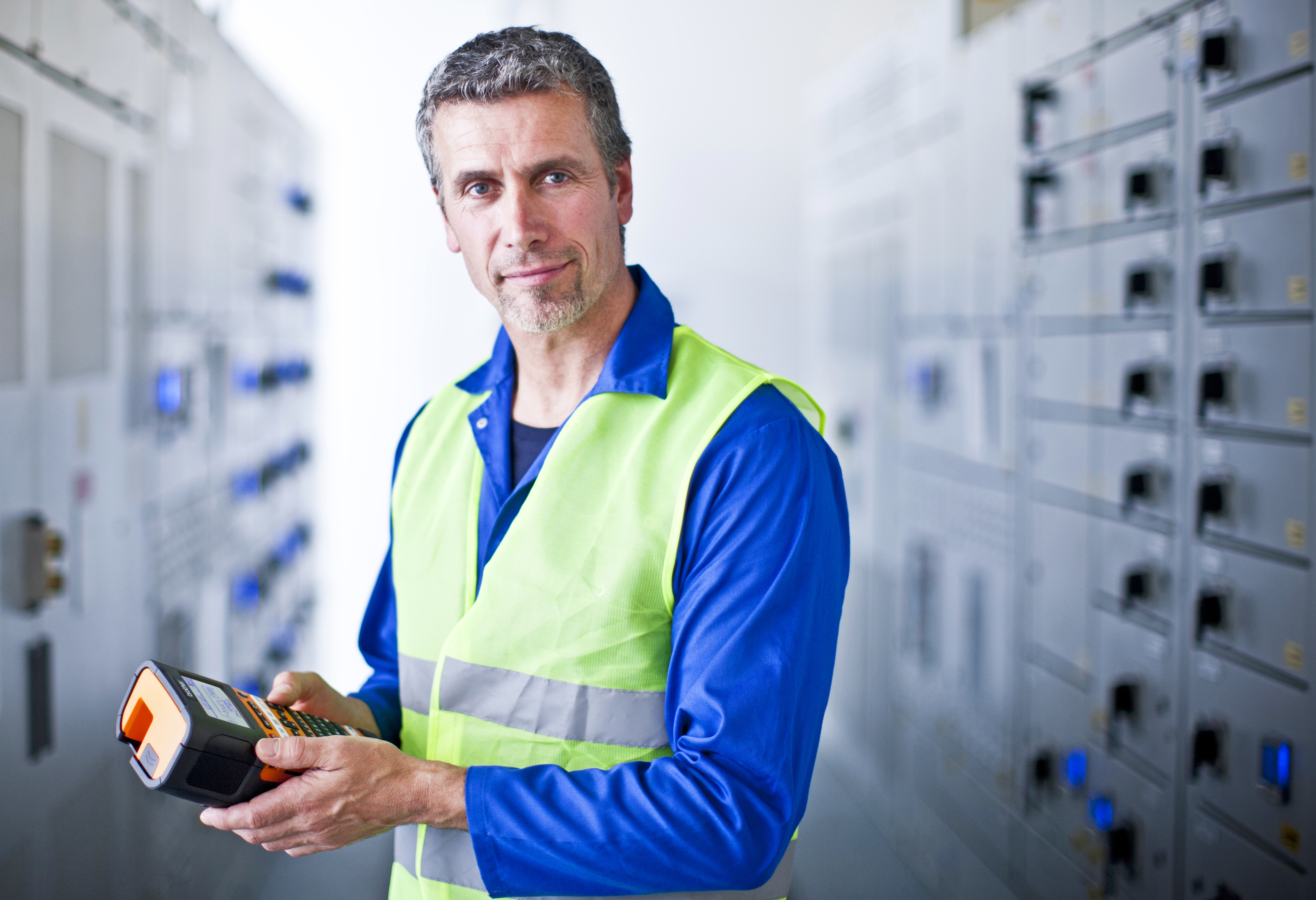 Male electrician holding a Brother PT-E550W label printer 