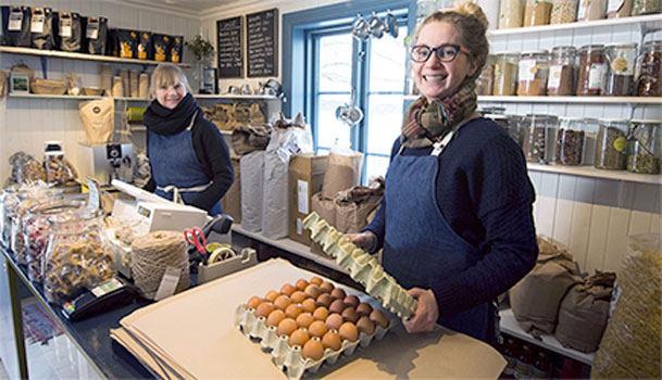 En butikkansatt med en kartong egg holder på med matmerking hos Fat&Fe 