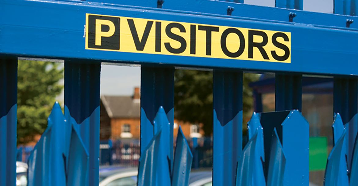 Black on yellow label showing visitor parking